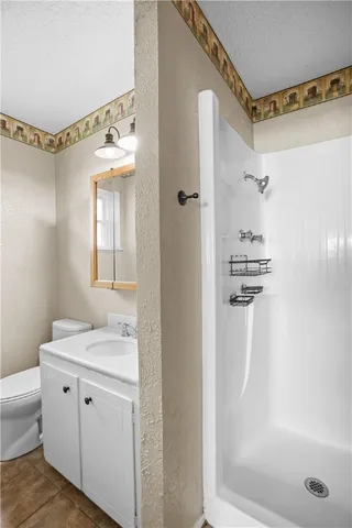 a bathroom with a granite countertop sink a mirror and a shower