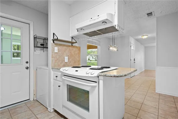a kitchen with granite countertop a stove and a sink