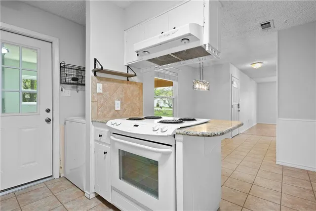 a kitchen with granite countertop a stove and a sink