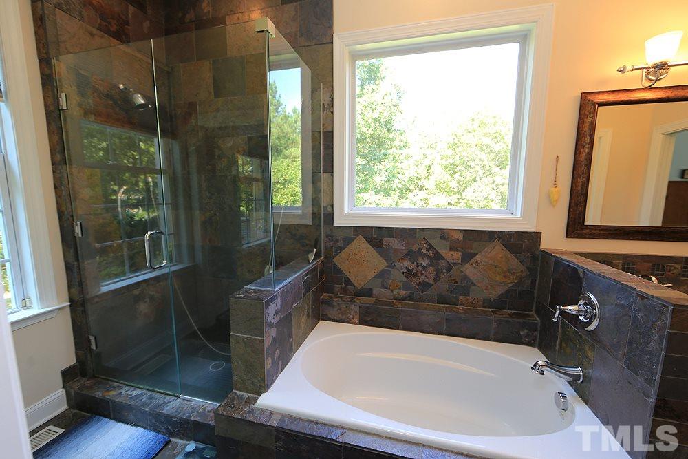 6844 Pond Road Wendell, NC 27591 - Photo 12 of 25 a bathroom with a bathtub and a shower