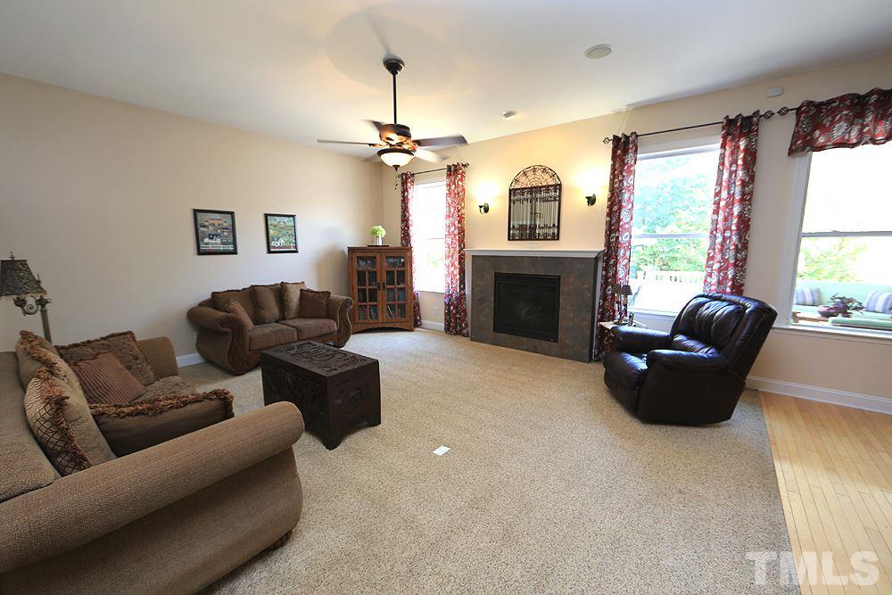 6844 Pond Road Wendell, NC 27591 - Photo 7 of 25 a living room with furniture a fireplace and a flat screen tv