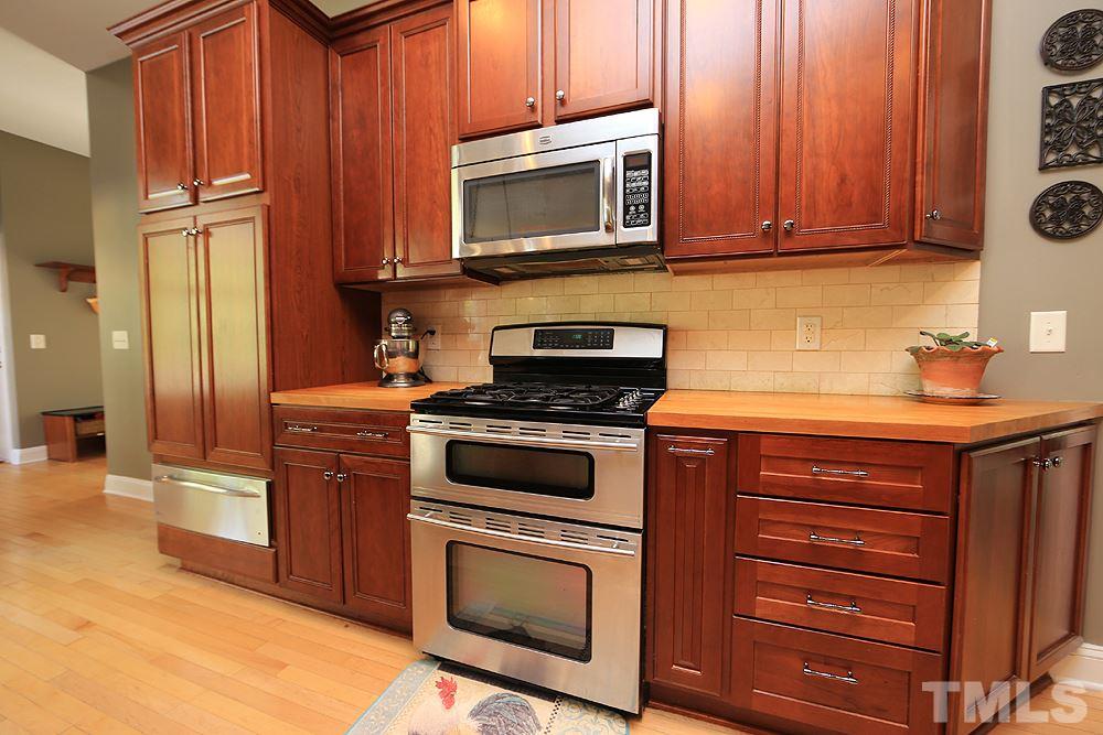 6844 Pond Road Wendell, NC 27591 - Photo 10 of 25 a kitchen with granite countertop wooden cabinets stainless steel appliances and a sink