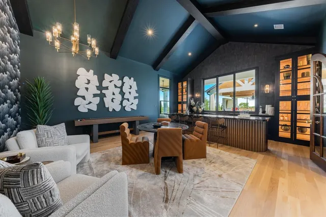 a living room with furniture a chandelier and a large window