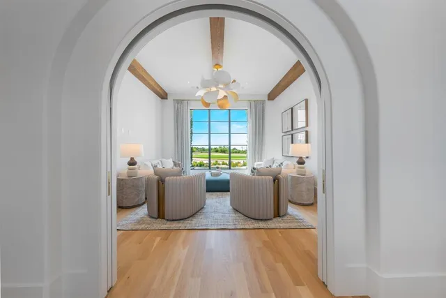 a living room with furniture a chandelier and a large window