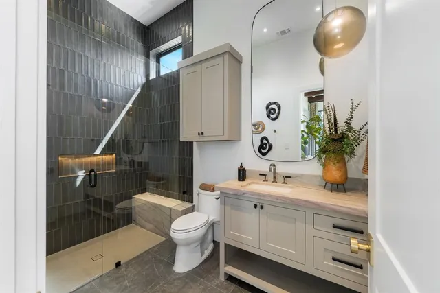 a bathroom with a toilet sink and mirror