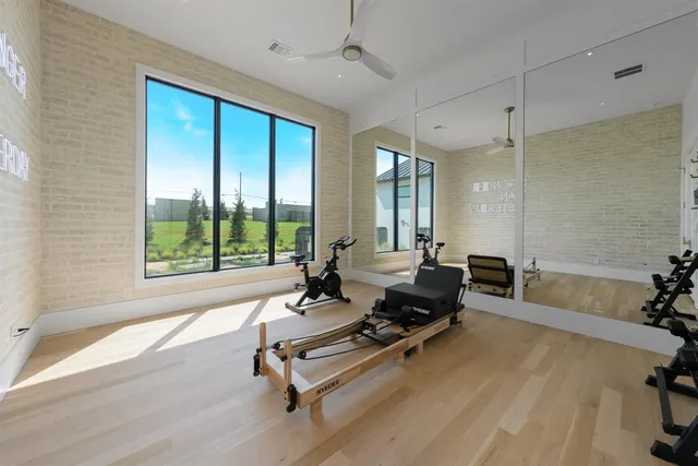 a living room with furniture gym equipment and a large window