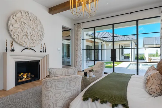 a living room with furniture a fireplace and a large window