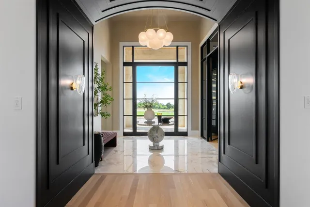 a view of a hallway with wooden floor windows and a livingroom