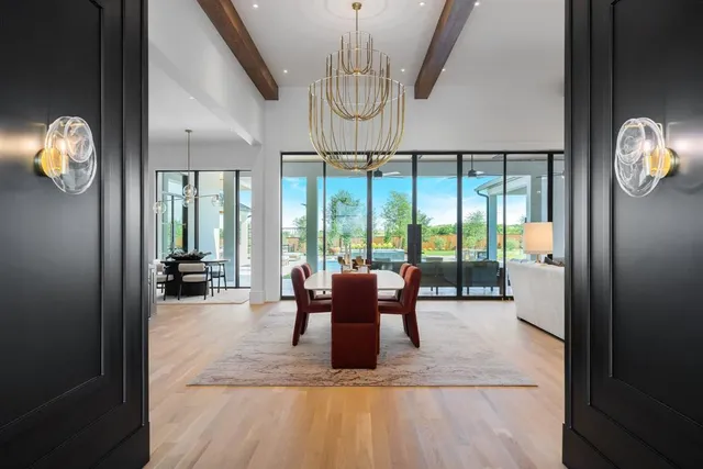 a dining room with furniture large windows and wooden floor