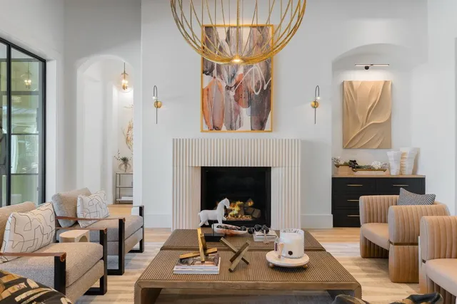 a living room with furniture a fireplace and a chandelier