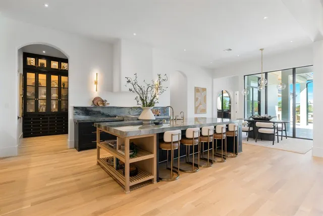 a dining hall with stainless steel appliances granite countertop a stove and a dining table chair