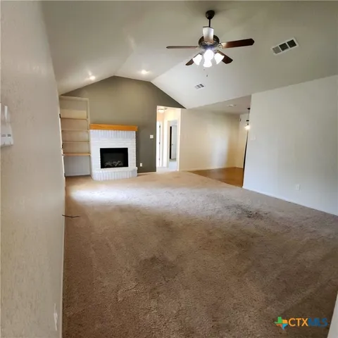 a kitchen with stainless steel appliances granite countertop a refrigerator a stove and a sink with wooden floor