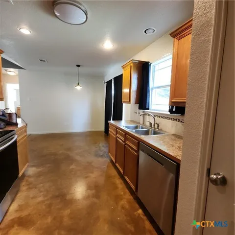a kitchen with stainless steel appliances a refrigerator and a window