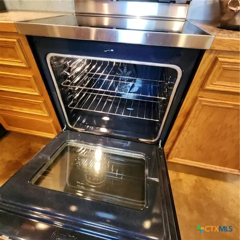a view of a big room with windows and chandelier fan