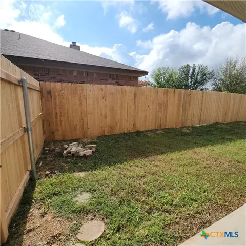 a view of a house with backyard and a tree
