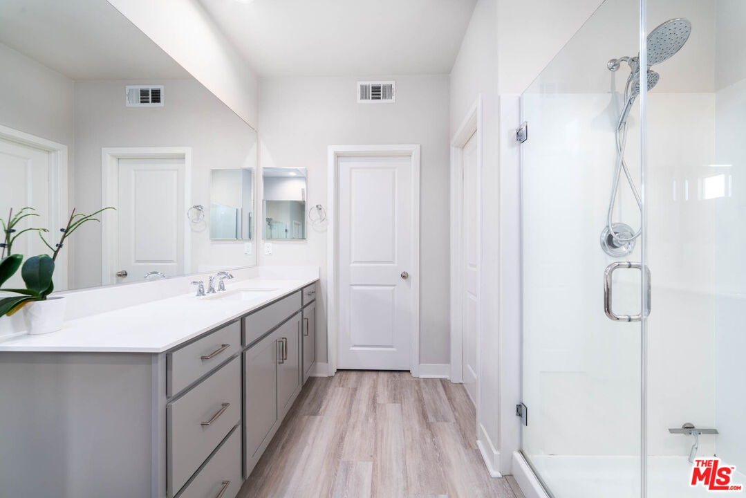 587 Daniel Freeman Circle Inglewood, CA 90301 - Photo 10 of 25 a bathroom with a double vanity sink mirror and shower