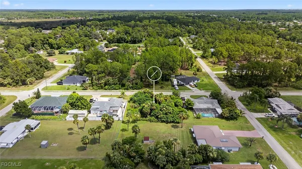 an aerial view of residential houses with outdoor space and trees