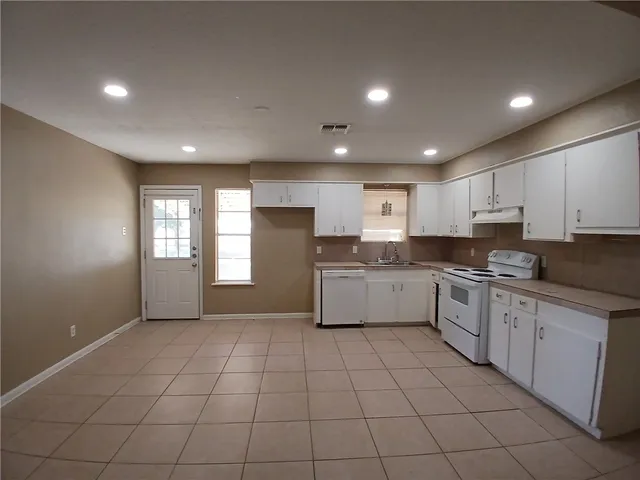 a kitchen with a white cabinets and white appliances