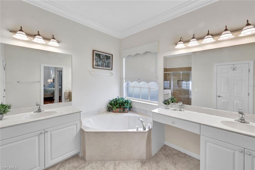 16208 Parque Lane Naples, FL 34110 - Photo 14 of 22 a bathroom with a sink vanity tub and a mirror