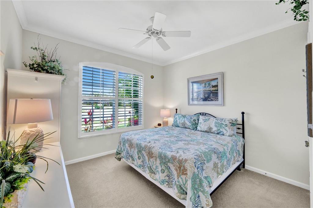 16208 Parque Lane Naples, FL 34110 - Photo 15 of 22 a bedroom with a large bed and a chandelier