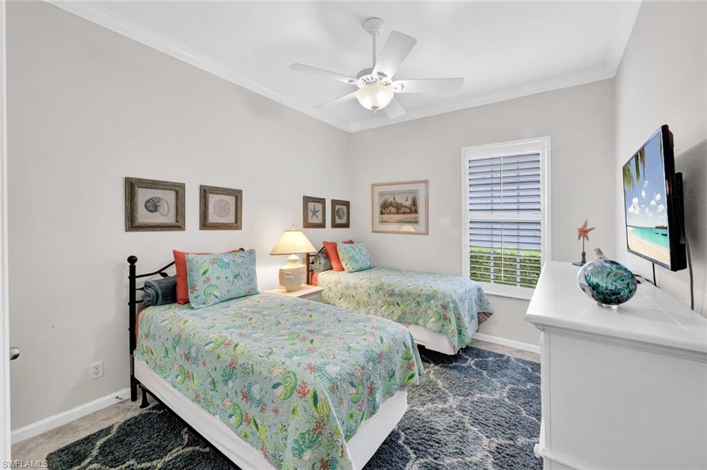 16208 Parque Lane Naples, FL 34110 - Photo 17 of 22 a bedroom with bed a flat tv screen and a dresser