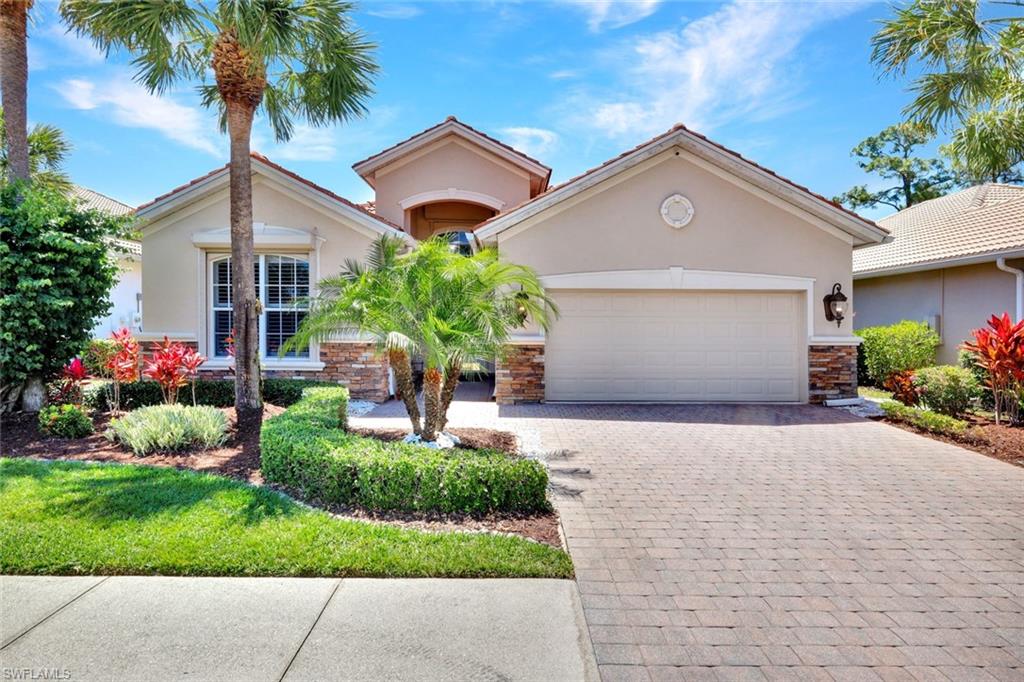 16208 Parque Lane Naples, FL 34110 - Photo 3 of 22 a front view of a house with a yard and a garage