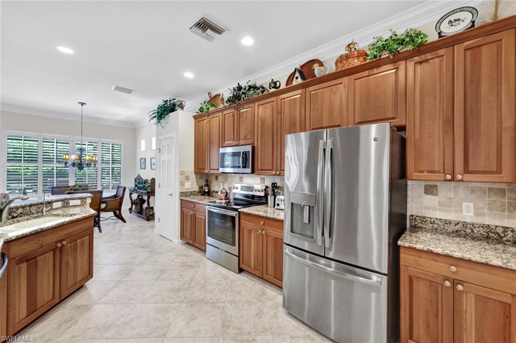 16208 Parque Lane Naples, FL 34110 - Photo 8 of 22 a kitchen with stainless steel appliances granite countertop a refrigerator a sink dishwasher stove and oven