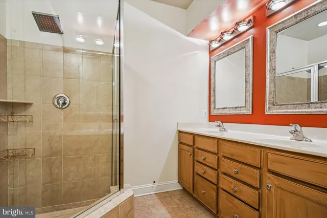 a bathroom with a double vanity sink mirror and shower