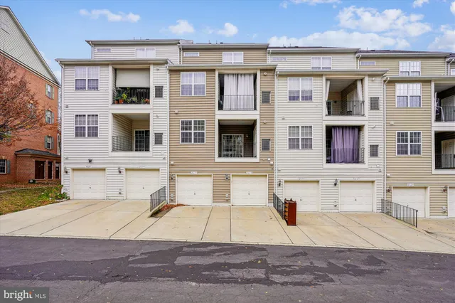 a view of a brick house with many windows and a yard