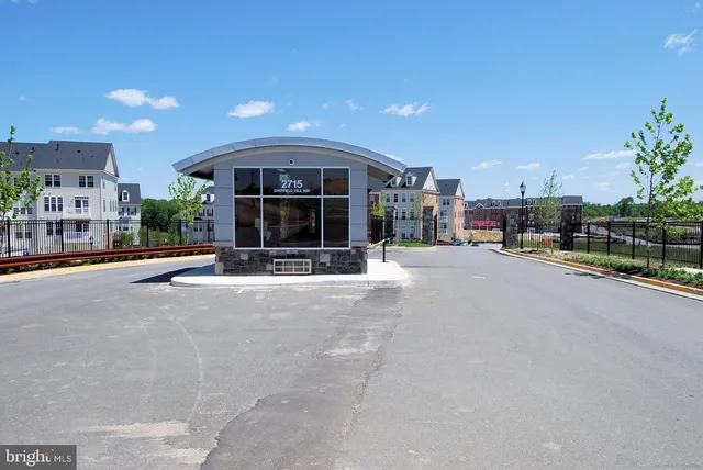 a front view of a residential apartment building with yard and parking space
