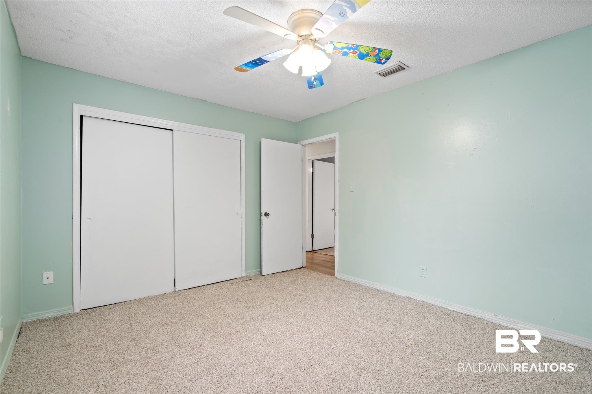 9445 Howells Ferry Road Semmes, AL 36575 - Photo 15 of 20 Unfurnished bedroom featuring a textured ceiling, light carpet, ceiling fan, and a closet