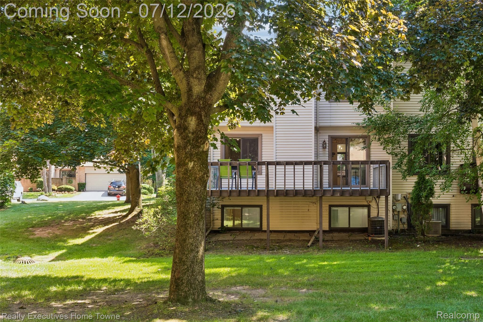 1077 Willow Grove Court Rochester, MI 48307 - Photo 27 of 34 Rear exterior featuring a wood deck, sliding glass door access, vinyl siding, and ground-level windows