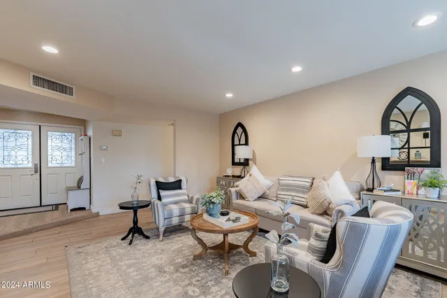 a living room with furniture a clock and a fireplace