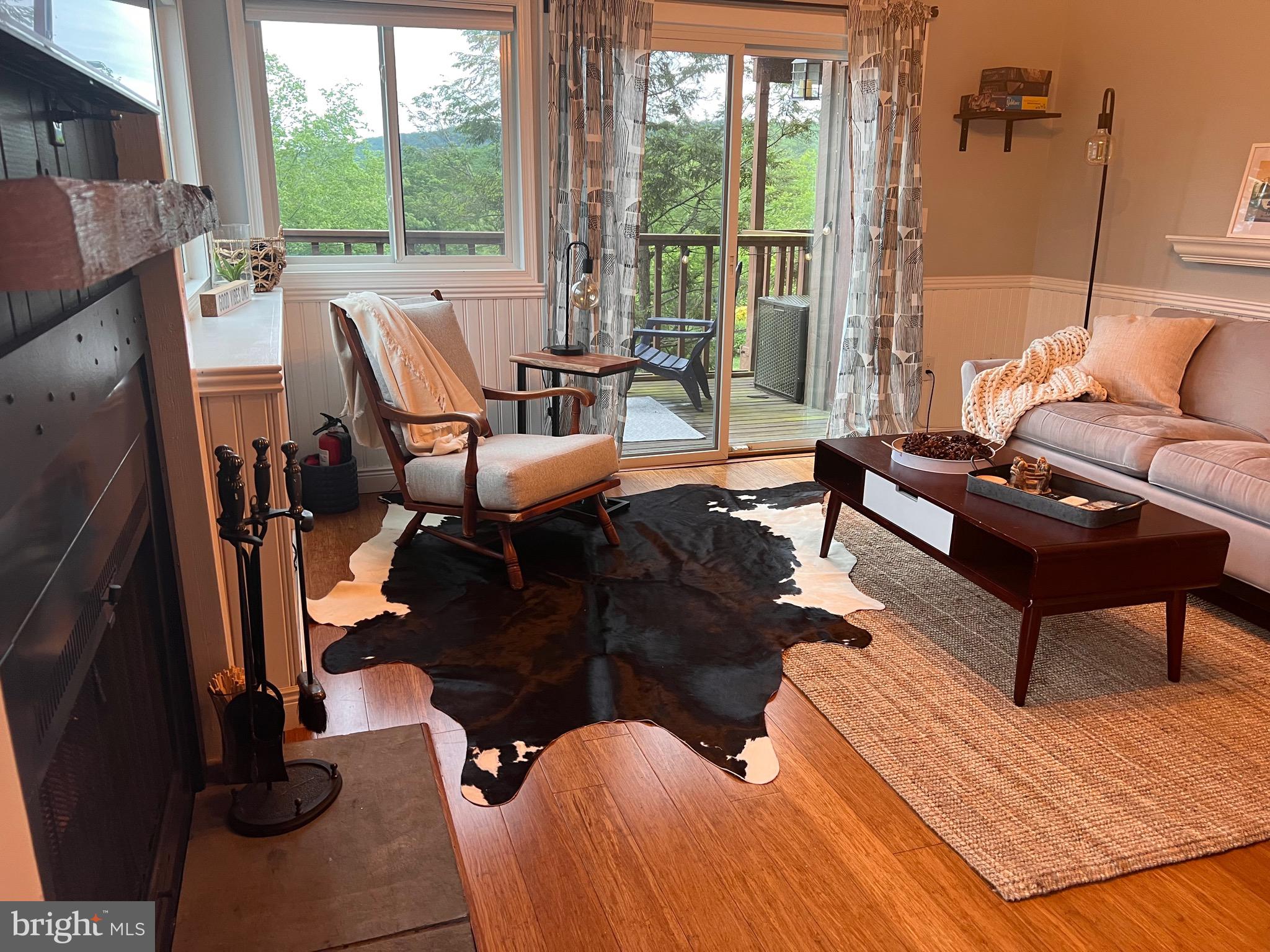 141 The Hill Road, Unit 25A Basye, VA 22810 - Photo 1 of 18 a living room with patio furniture and a floor to ceiling window
