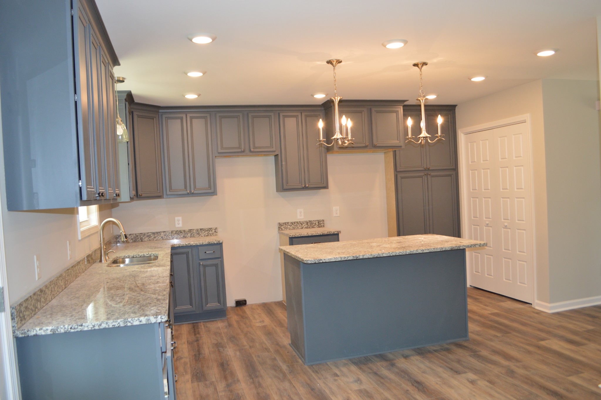 7713 South Swift Road Goodlettsville, TN 37072 - Photo 17 of 18 a large kitchen with stainless steel appliances granite countertop a sink a stove and a wooden floors