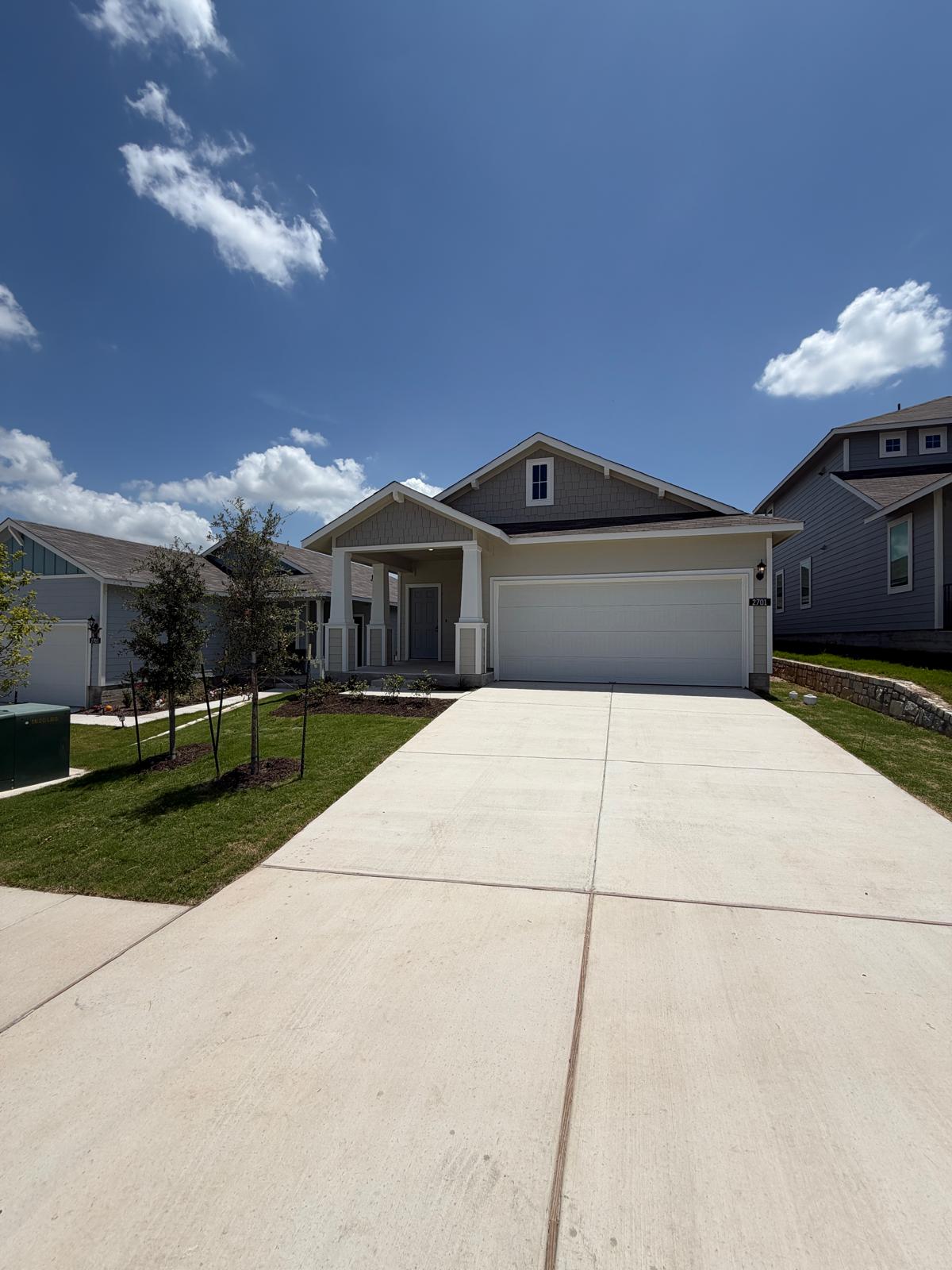 2701 Towy Road Manor, TX 78653 - Photo 3 of 35 A welcoming front exterior showcasing a broad driveway and neat landscaping.