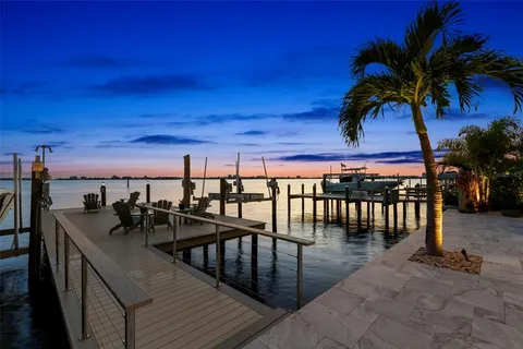 a view of a balcony with chairs and wooden fence