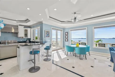 a kitchen with stainless steel appliances granite countertop a sink a stove a refrigerator cabinets and a window