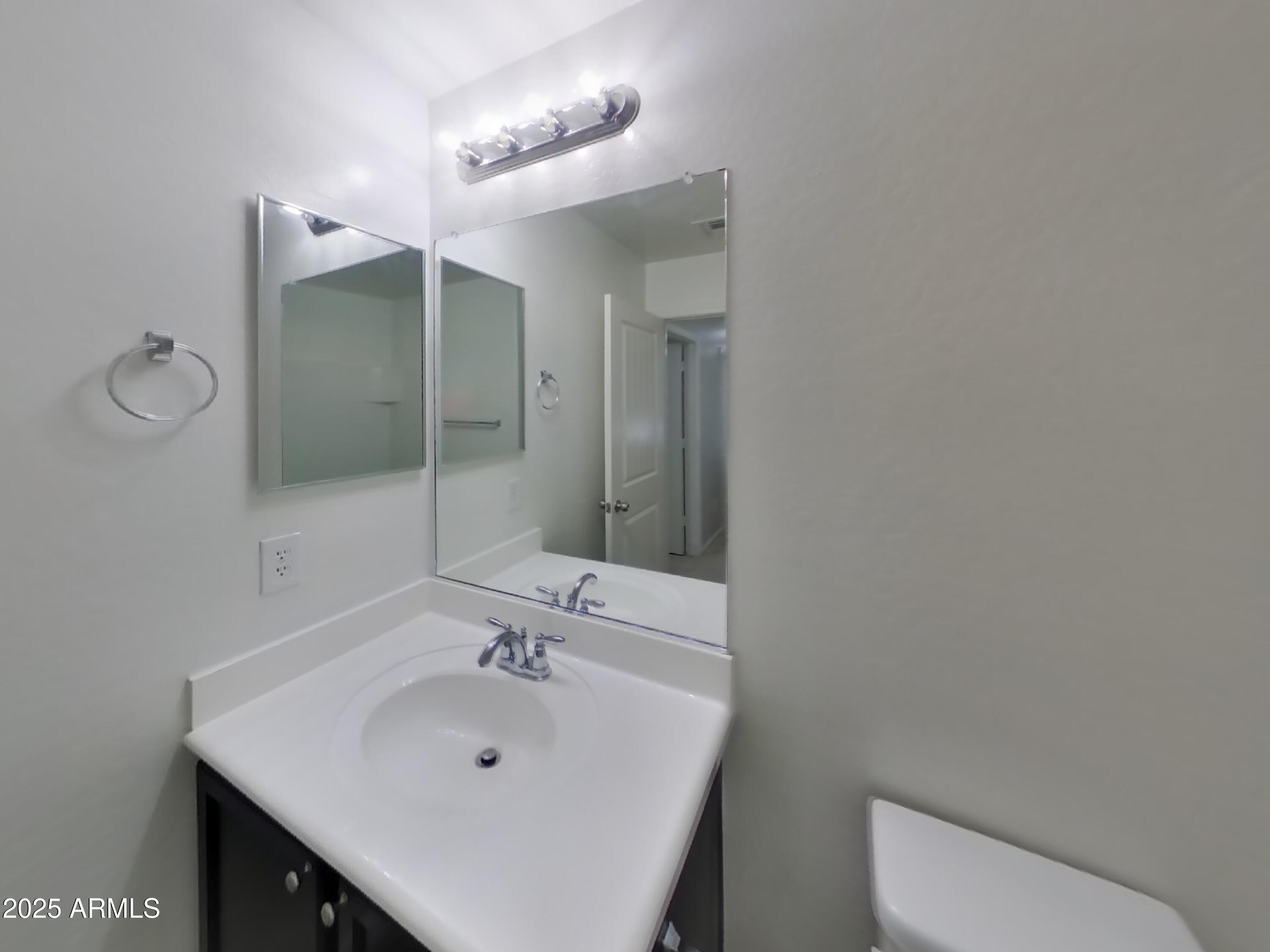 3513 South 89th Avenue Tolleson, AZ 85353 - Photo 15 of 19 a bathroom with a sink a toilet and mirror