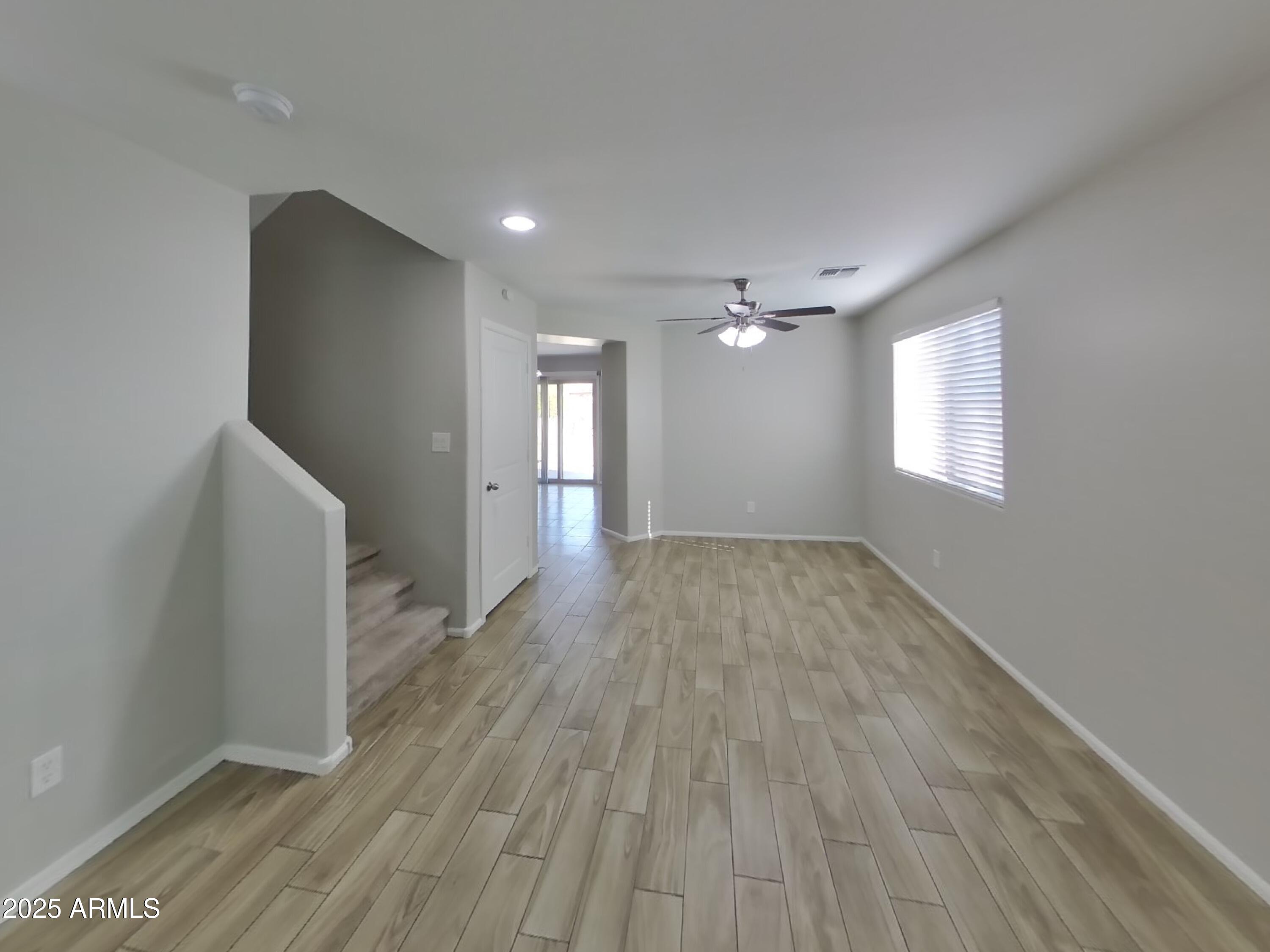 3513 South 89th Avenue Tolleson, AZ 85353 - Photo 3 of 19 an empty room with wooden floor and windows