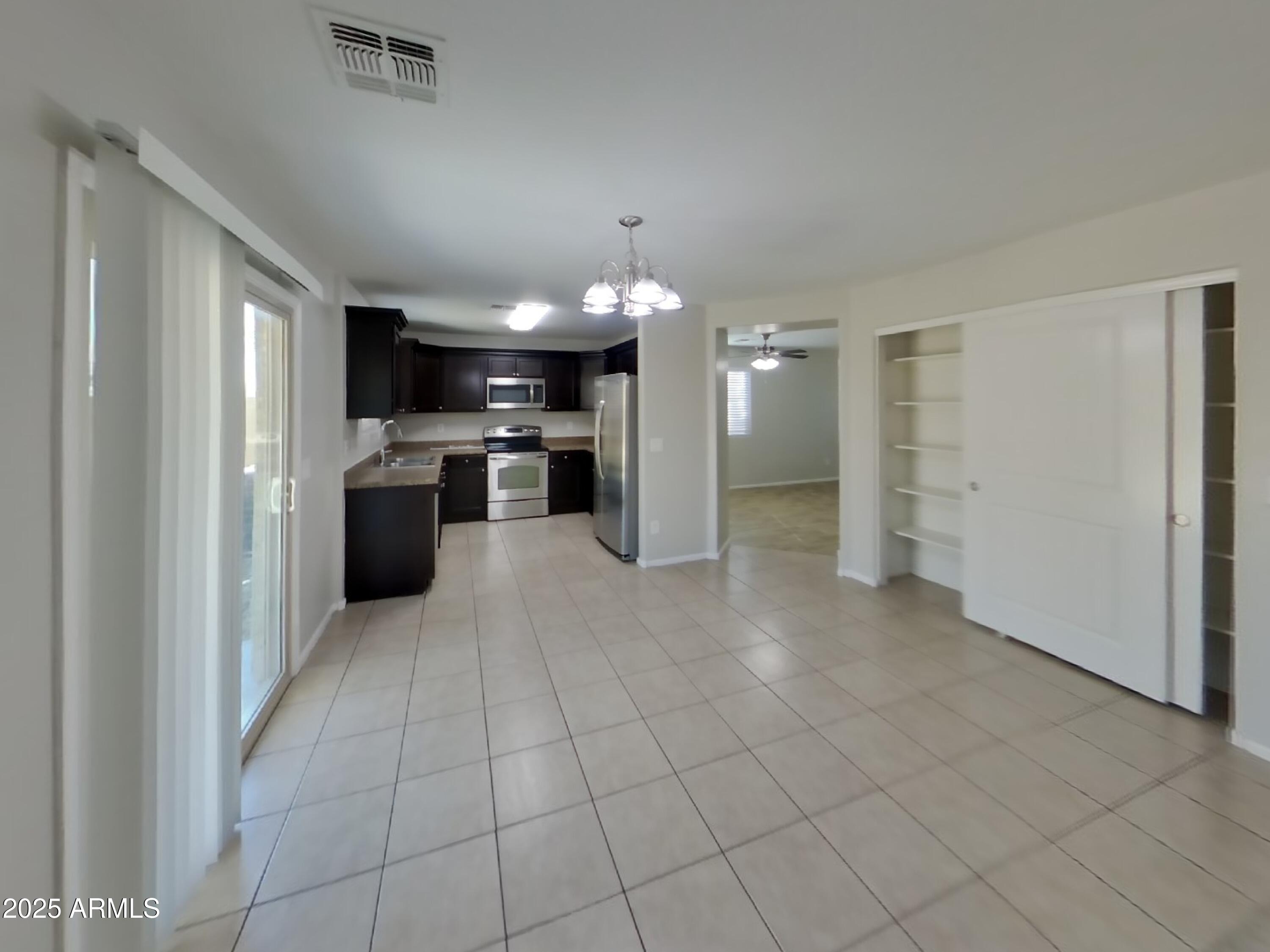 3513 South 89th Avenue Tolleson, AZ 85353 - Photo 4 of 19 a view of a electric appliances in kitchen and a livingroom with furniture