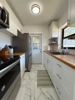 a large kitchen with cabinets and stainless steel appliances