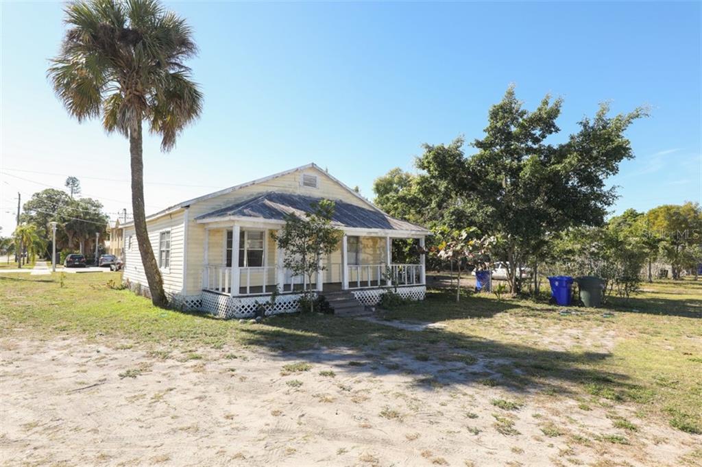 a front view of a house with yard and tree