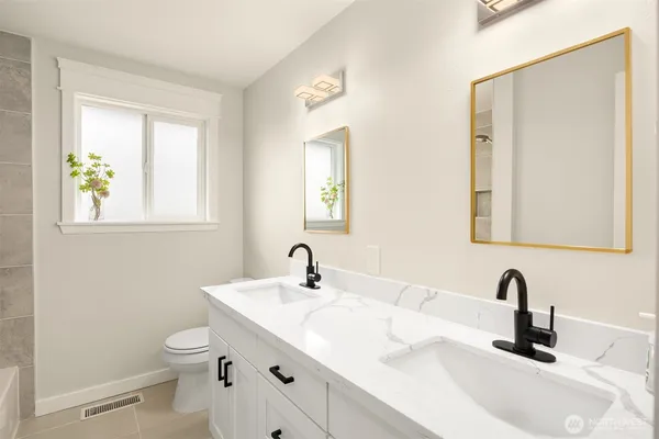 a bathroom with a double vanity sink toilet and a mirror