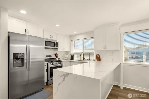 a kitchen with stainless steel appliances a refrigerator sink and stove