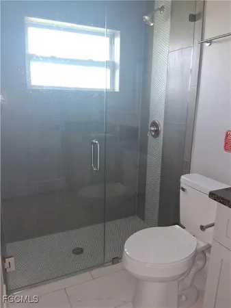 a bathroom with a toilet and a shower