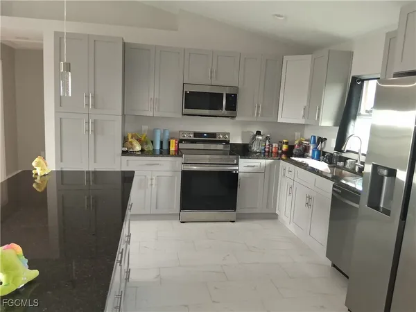 a kitchen with stainless steel appliances granite countertop a stove a sink dishwasher and a refrigerator