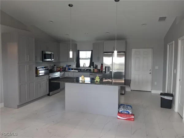 a kitchen with refrigerator and cabinets