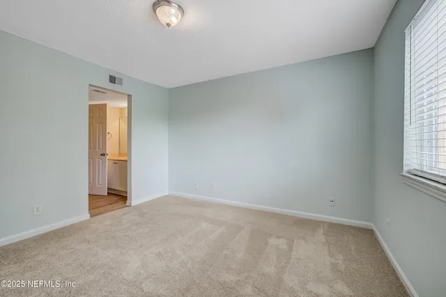 an empty room with windows and closet