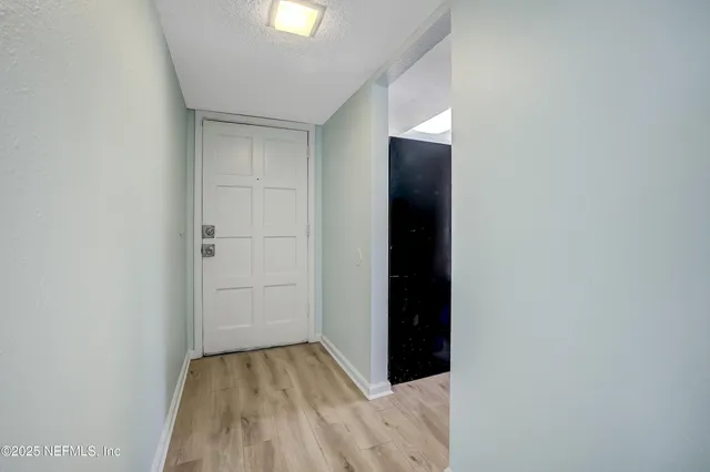 a view of an empty room with closet and wooden floor